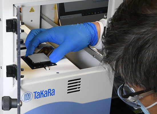 Researcher inserting chip into SmartChip system stage module